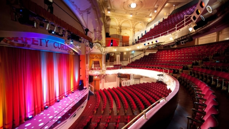 Interior of the Pavilion Theatre showing the stage, red seating and ornate auditorium.
