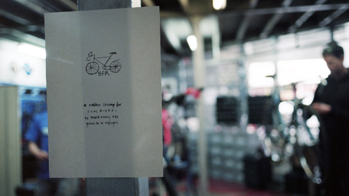 An artist poster sits in the bike repair cafe. 