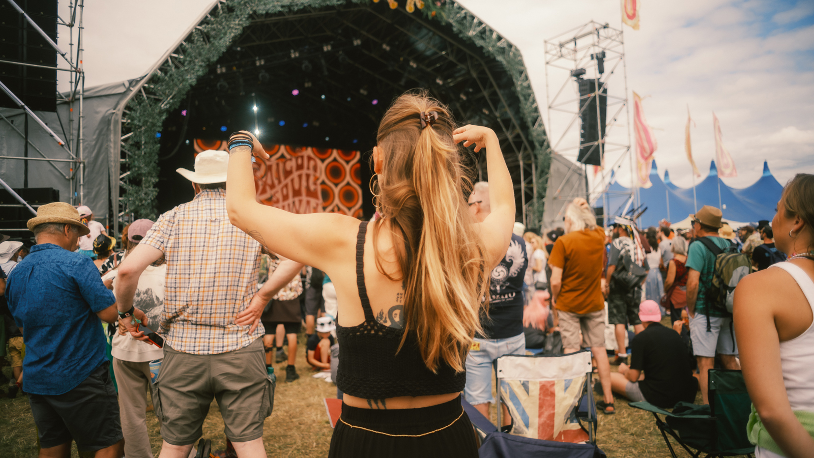 Music fans dance in front of a stage during a festival