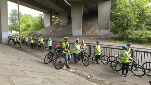 A group of young children on bikes are escorted through Glasgow M8.