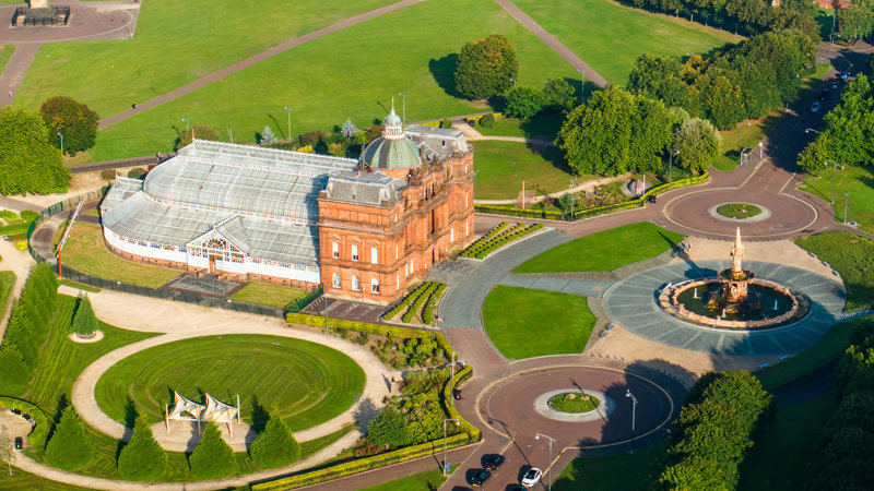 Aerial view of the People's Palace and Winter Gardens building in Glasgow Green on a sunny day.
