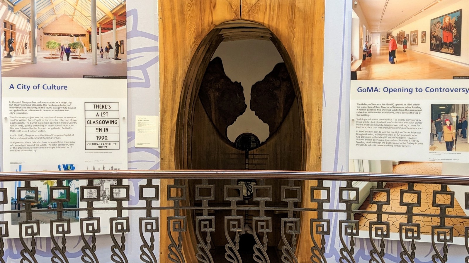 A wooden sculpture shaped like a peephole carved in different kinds of wood and inserted in the walls of a balcony space.