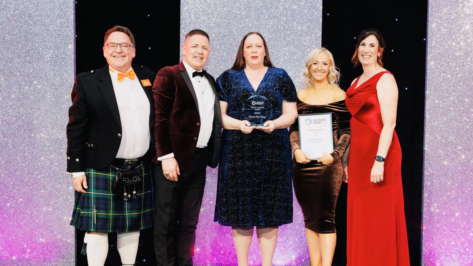 A group of five people on stage at an award ceremony