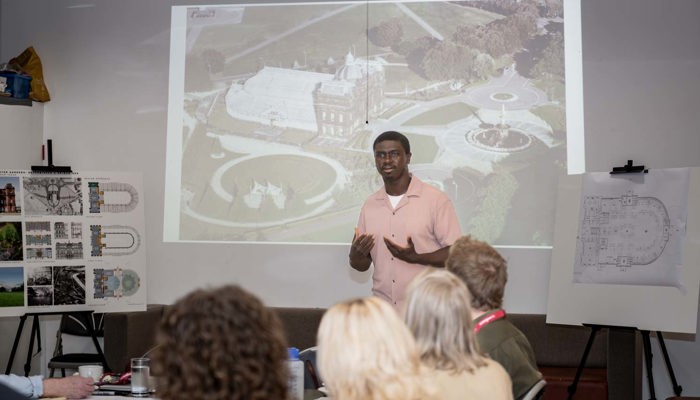 Dr Yahya Barry speaking at a People's Palace Community Partners' Panel meeting while other people are sitting listening.