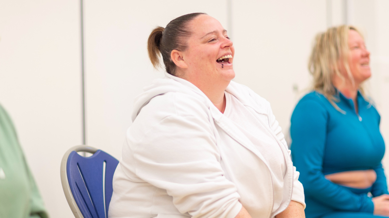 Three people sitting down smiling and laughing