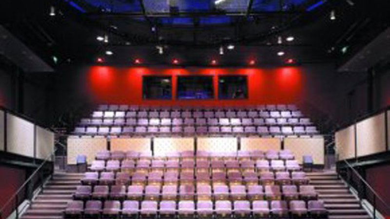 Tiered seating inside a modern theatre auditorium viewed from the stage.