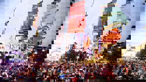 Music fans enjoy a festival as multicoloured flags fly above