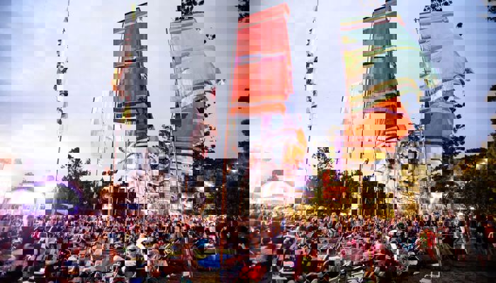 Music fans enjoy a festival as multicoloured flags fly above